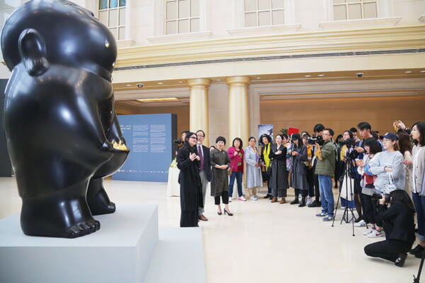 艺术家李真（左一）在展览开幕当天为记者讲述作品理念