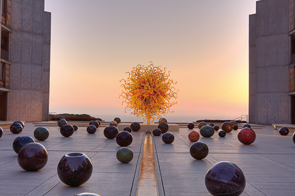奇胡利将玻璃艺术的尺度大幅提升，跃身地景艺术主角，图中背景为建筑家路易康名作——加州索尔克研究所。