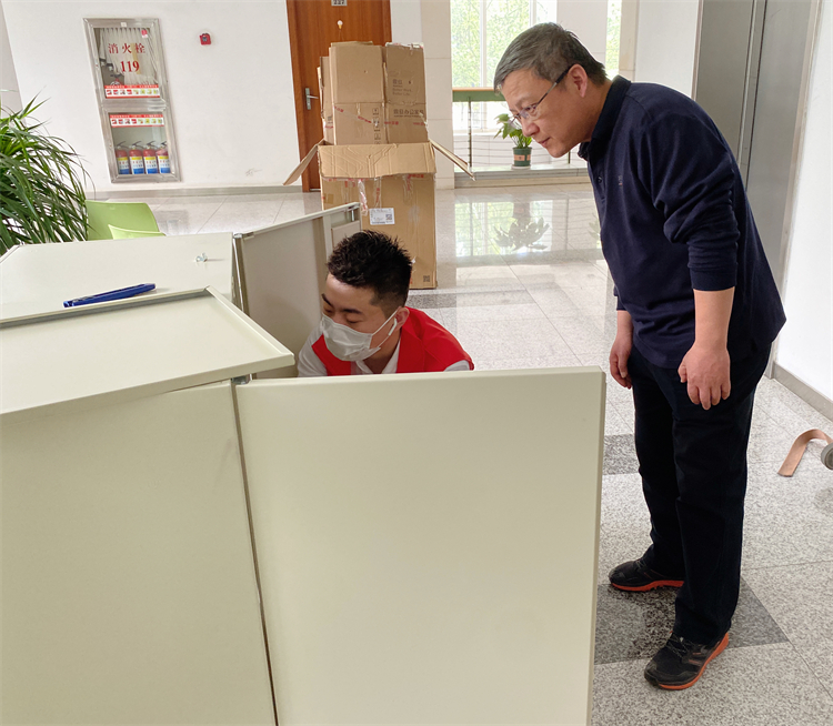 同仁杨宇向方老师介绍钢柜。